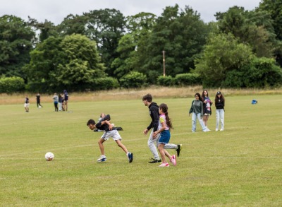 Students playing football on the grass in Cirencester