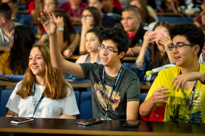 Student raising their hand in a lecture hall