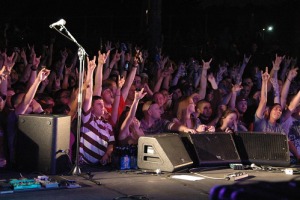 crowd dancing and holding up the hand gesture for rock and roll