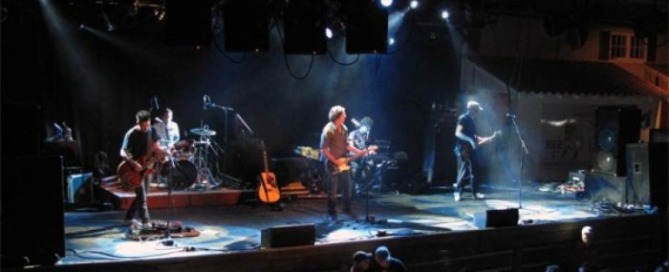 one of the most famous british rock bands performing live on stage with stage lights and guitars