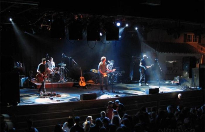 one of the most famous british rock bands performing live on stage with stage lights and guitars