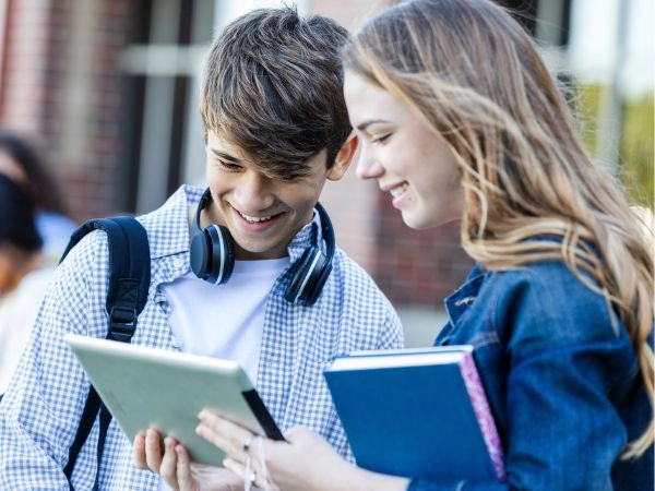 children on a study holiday looking at textbooks together