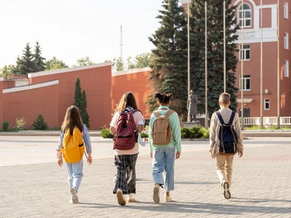 teenagers walking across a school campus