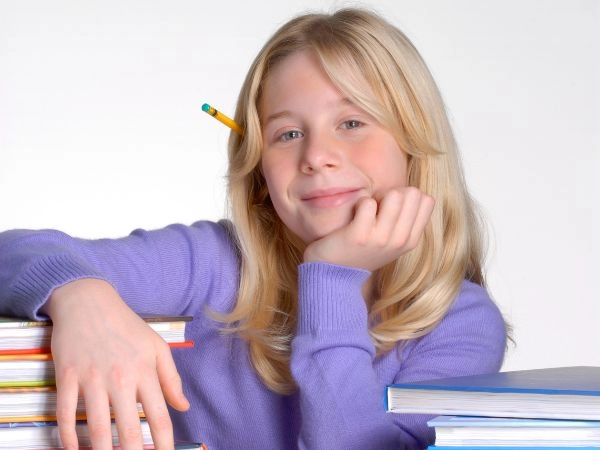child resting their arm on school textbooks with a pencil in their ear